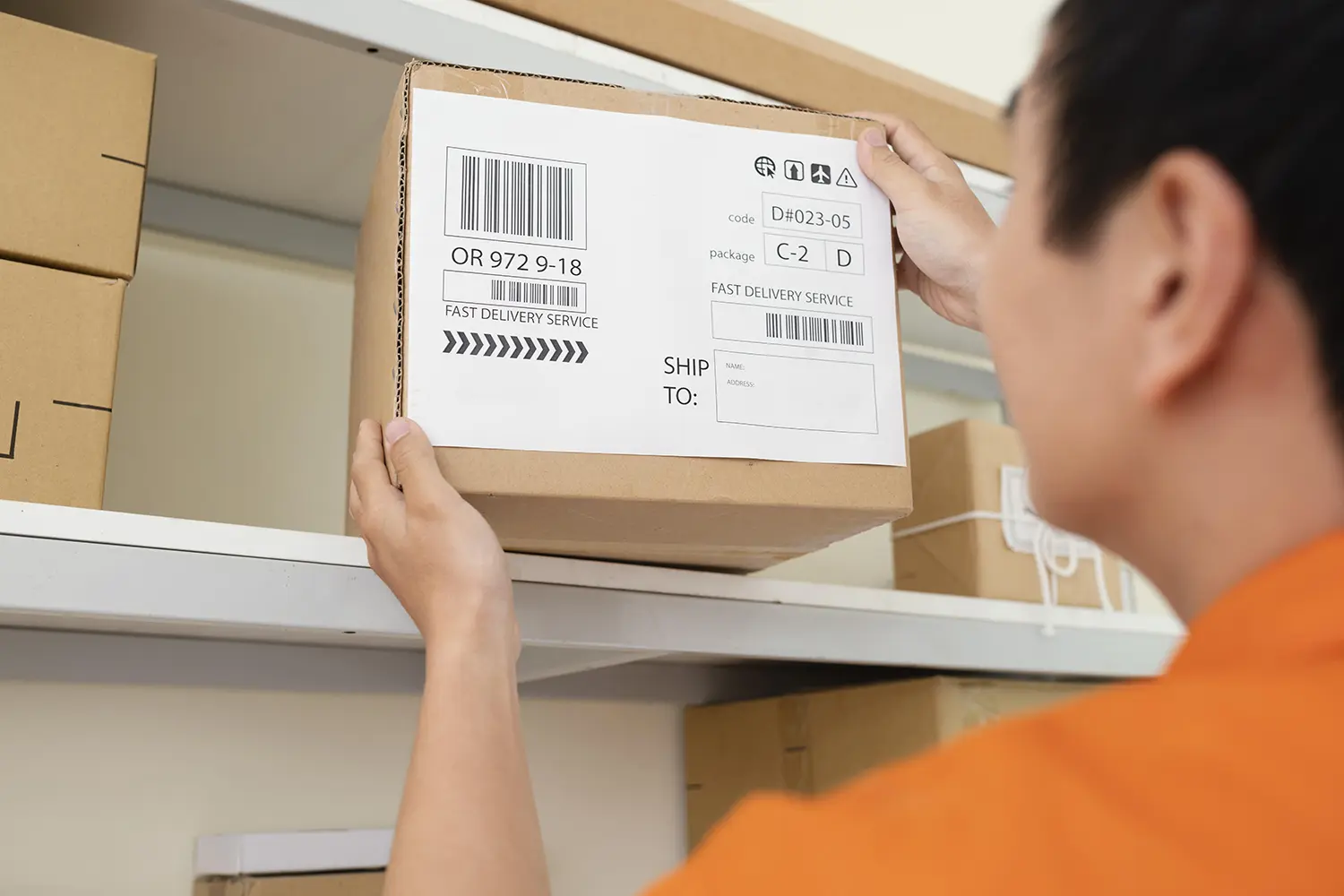 man picking up delivery parcel showing delivery note with barcode