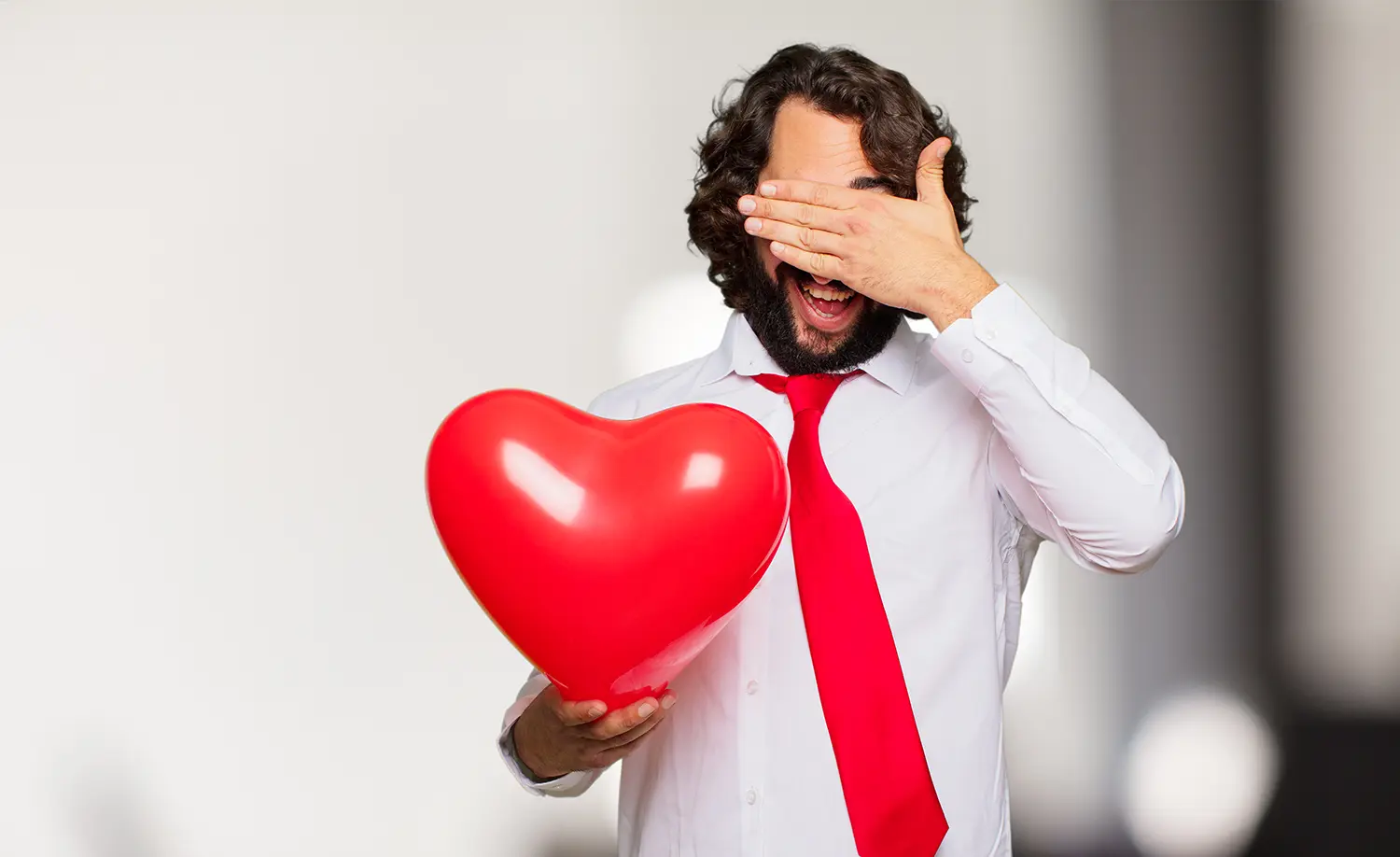 valentines day catastrophe man covering eyes with red heart balloon in hand